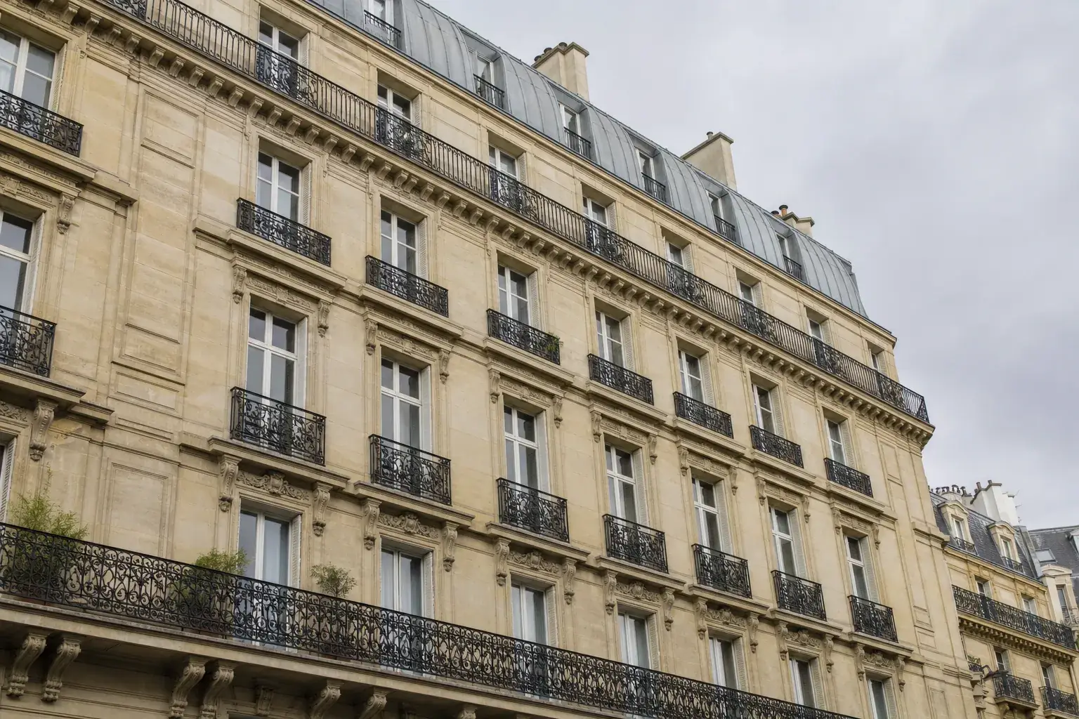 Immeuble haussmannien parisien en copropriété, pierre de taille et balcons filants